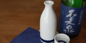 Bottle of sake pictured with a Tokkuri carafe and an Ochoko cup, helping describe the meaning of brewing year.