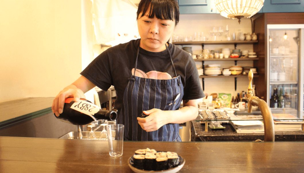 Marie Chiba is pouring sake into a glass